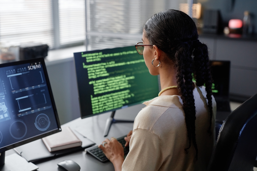 Software developers collaborating at workstations to plan and implement an IBM Notes migration for improved enterprise application management.