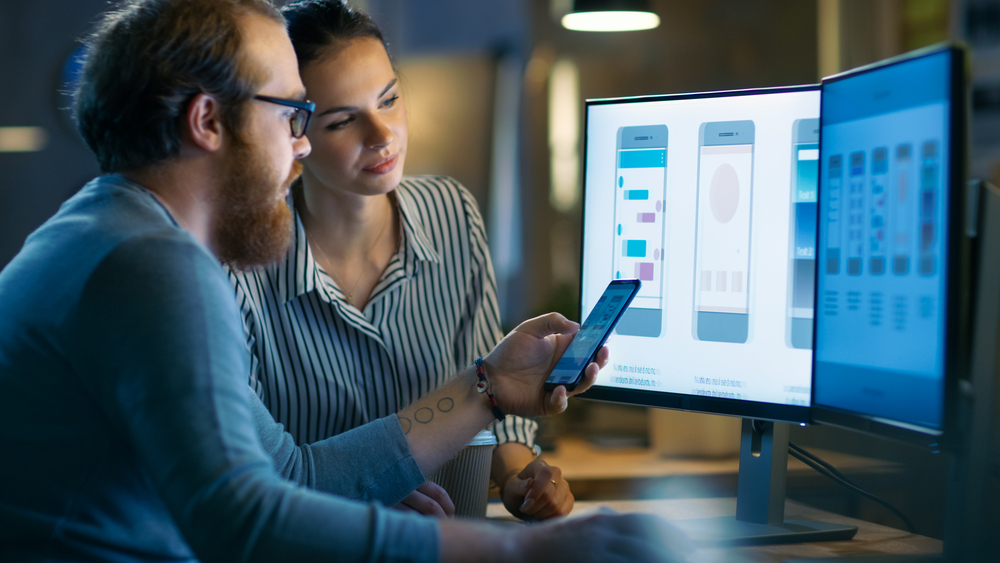 Professional monitoring enterprise applications on multiple screens with application inventory helping identify legacy systems and support modernization initiatives.