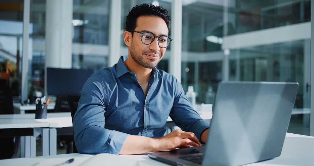 Software developer working on legacy system modernization code at a workstation.