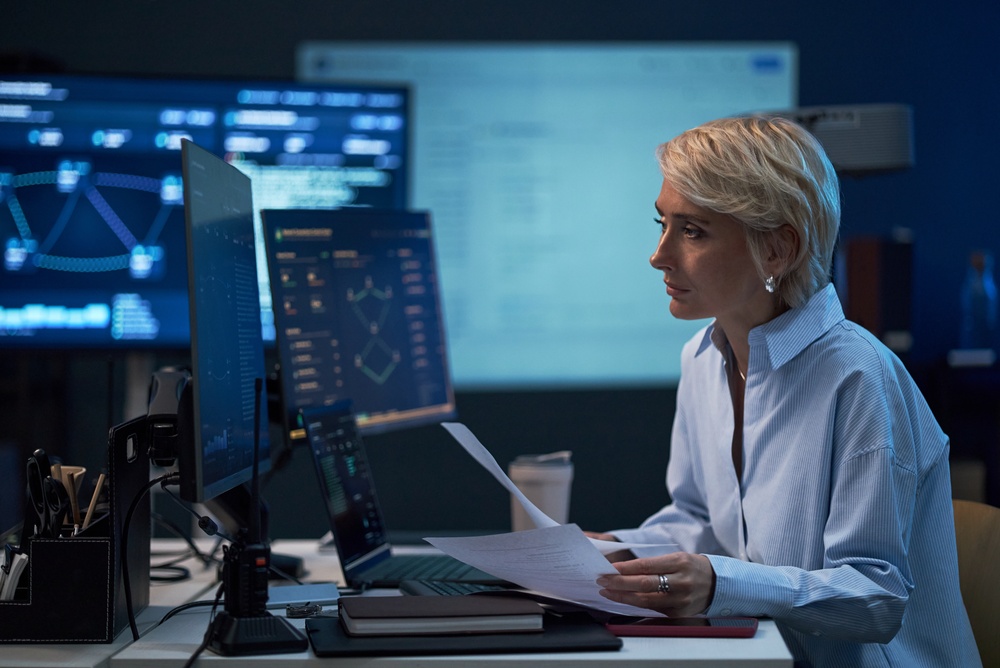 CIO evaluating legacy system modernization progress on a computer dashboard.