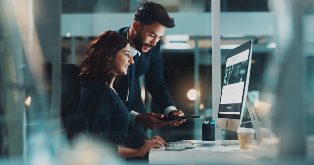 Technology consultant reviewing enterprise migration plans on a desktop computer to migrate lotus domino to exchange efficiently and securely.