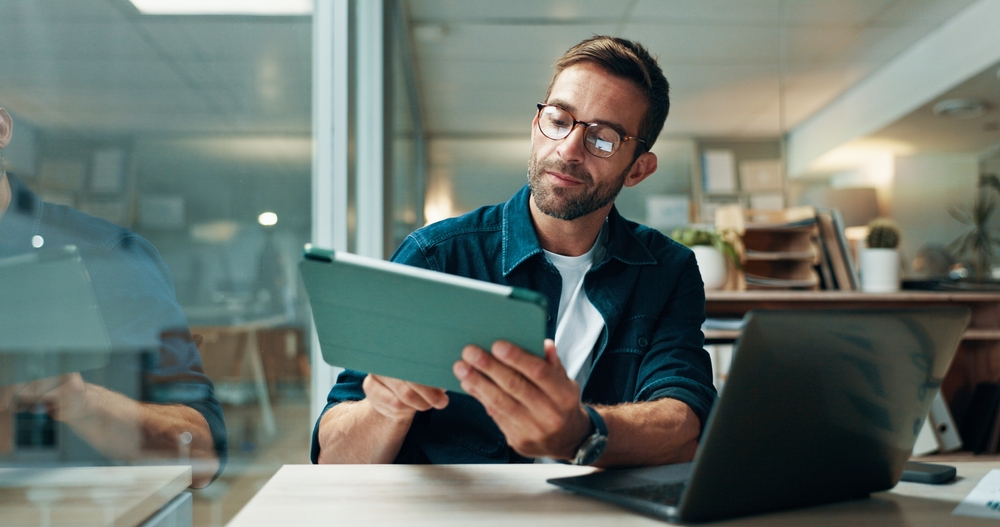 Software specialist collaborating with colleagues on a workstation to migrate lotus domino to exchange and modernize enterprise messaging systems.